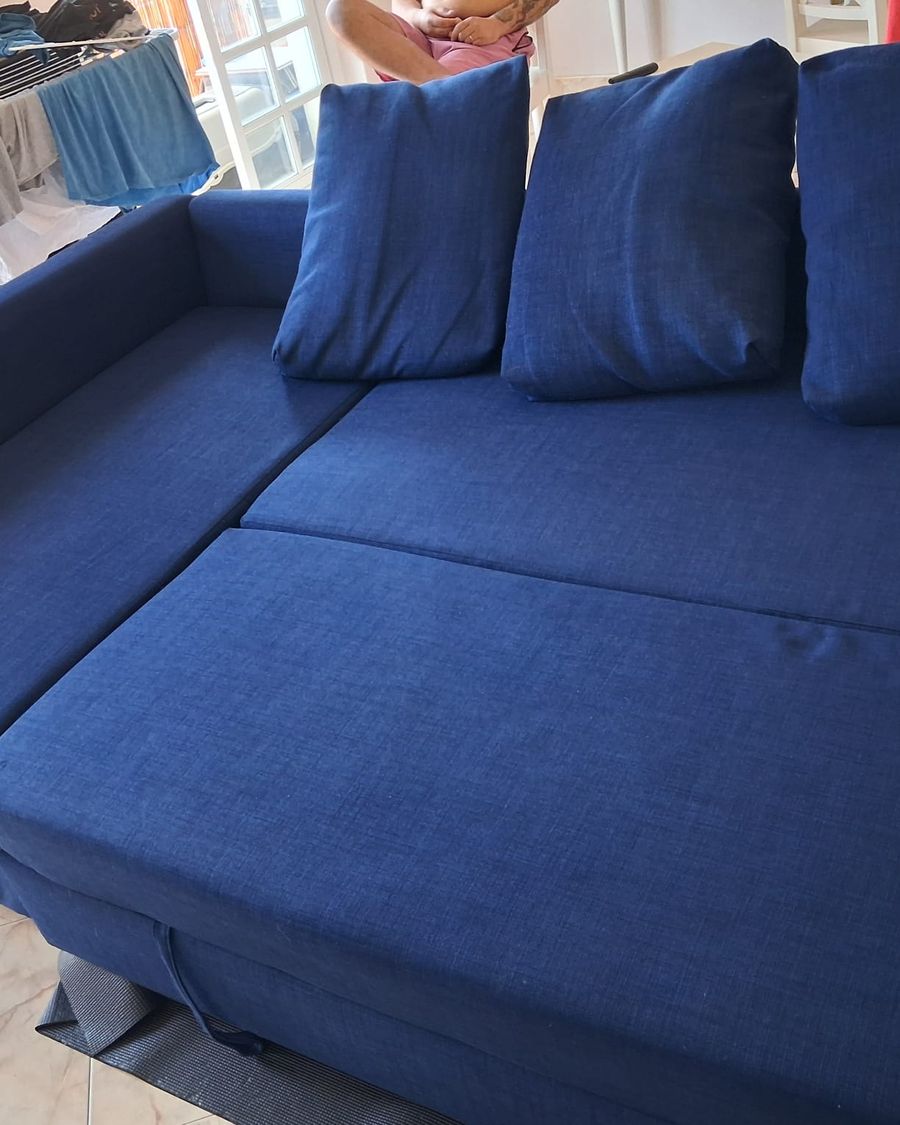 Sofá azul, limpo e com as almofadas no lugar
