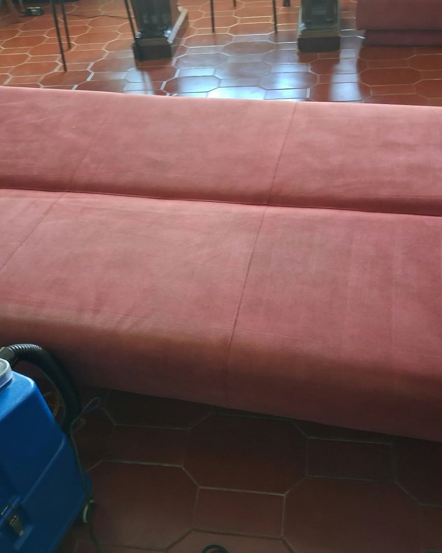 O mesmo sofá-cama depois da limpeza, com a máquina de extração ao lado